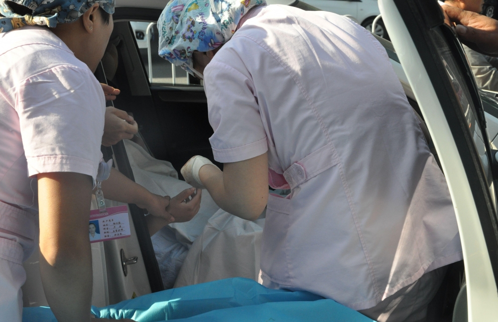 孕妇医院门口生产在即 医护人员搭人墙车内接生