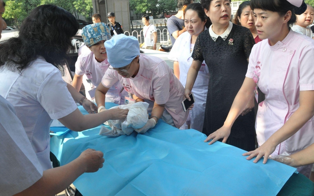孕妇医院门口生产在即 医护人员搭人墙车内接生