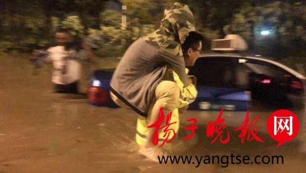 镇江暴雨致一出租车被困水中 暖心交警深夜趟水背乘客脱险