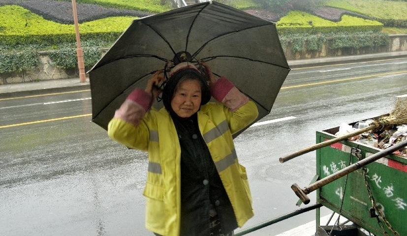 阴雨连绵,环卫工人大妈用旧雨伞和铁线圈自制“避雨神器”