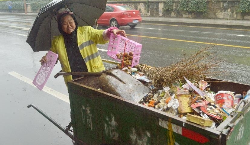 阴雨连绵,环卫工人大妈用旧雨伞和铁线圈自制“避雨神器”