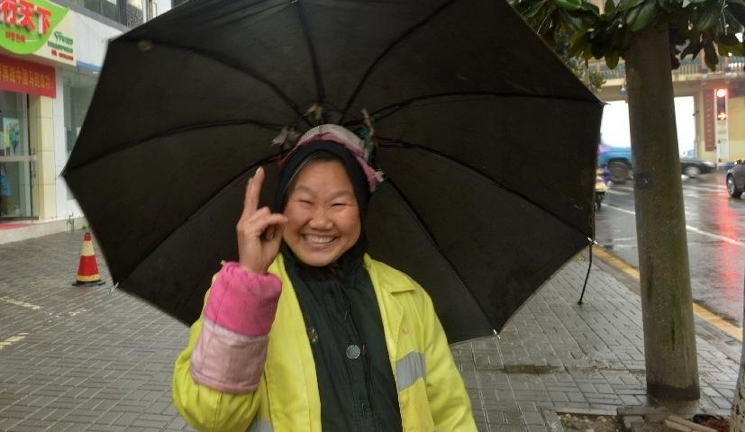 阴雨连绵,环卫工人大妈用旧雨伞和铁线圈自制“避雨神器”
