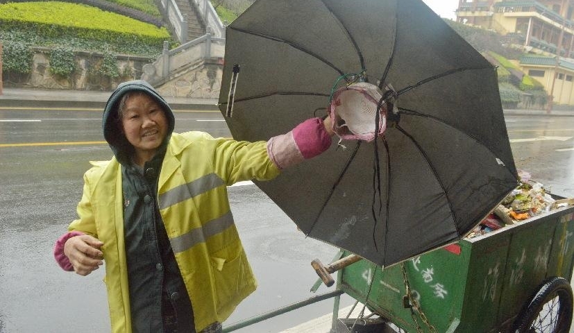 阴雨连绵,环卫工人大妈用旧雨伞和铁线圈自制“避雨神器”
