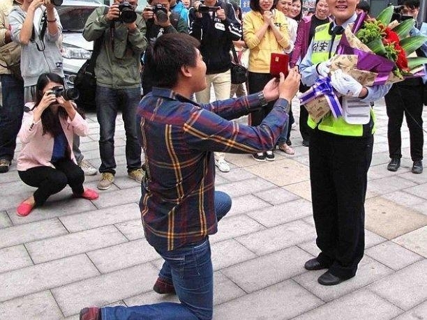 С���ڽ�ͷ���ڵ�ϥ������Ů������飬��ʶ�������˺�Ц��ů