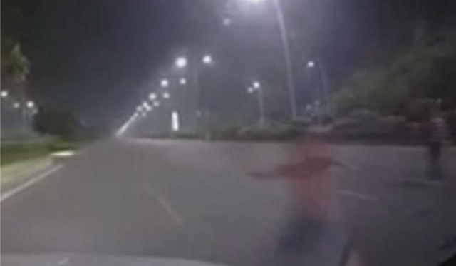 舍命碰瓷!男子蹲守路中央 见疾驰车辆就往上靠