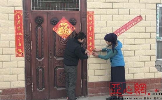 新疆阿克苏市市场监督管理局驻村工作队与村民贴春联挂灯笼