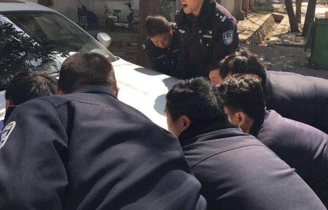 老人开车,轮胎掉进污水沟 警察给力,数十人抬出轿车
