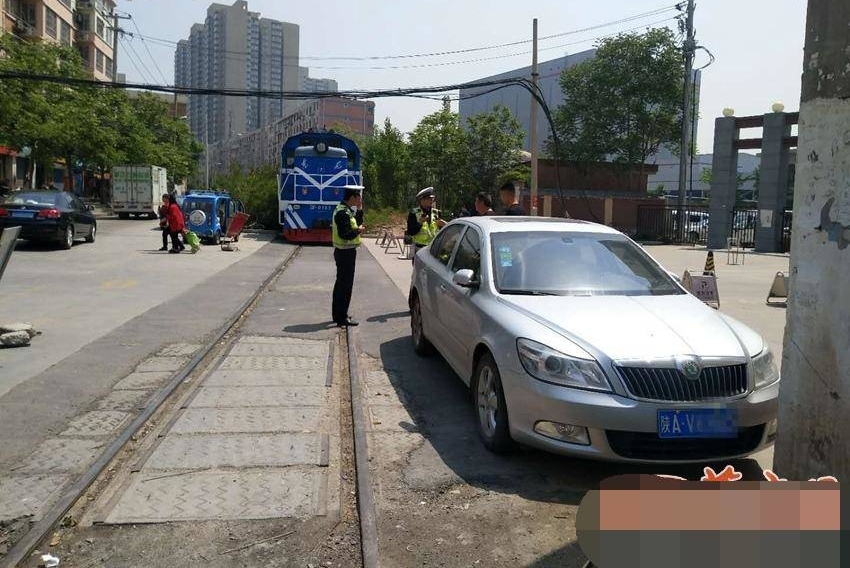 轿车停在铁道旁 火车被逼停堵了半个多小时
