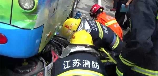 外卖小哥疑似行车看手机 连车带人滑入公交车底