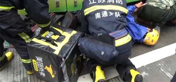 外卖小哥疑似行车看手机 连车带人滑入公交车底